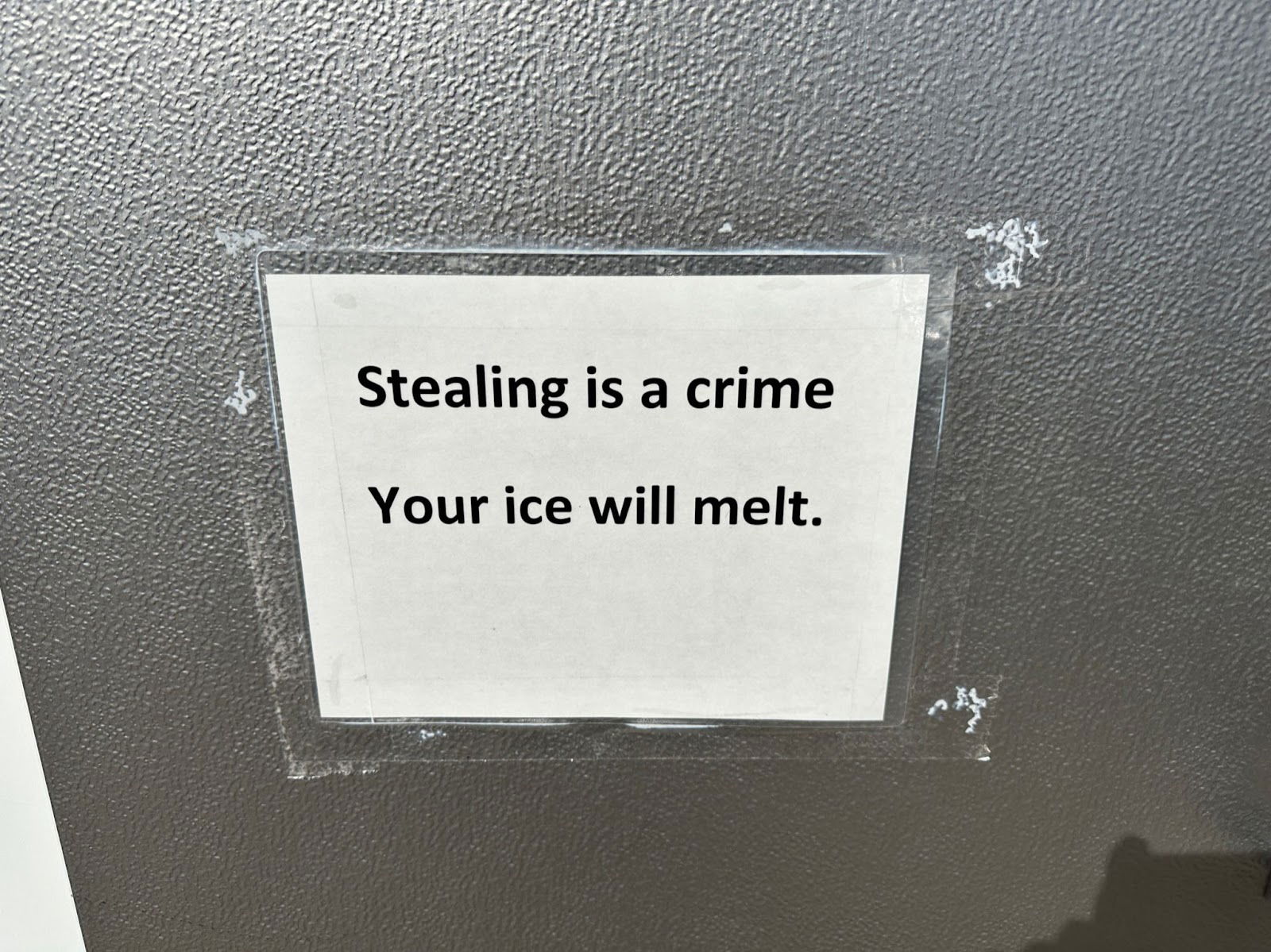 Stealing-prevention-sign-seen-on-a-gas-station-ice-cooler