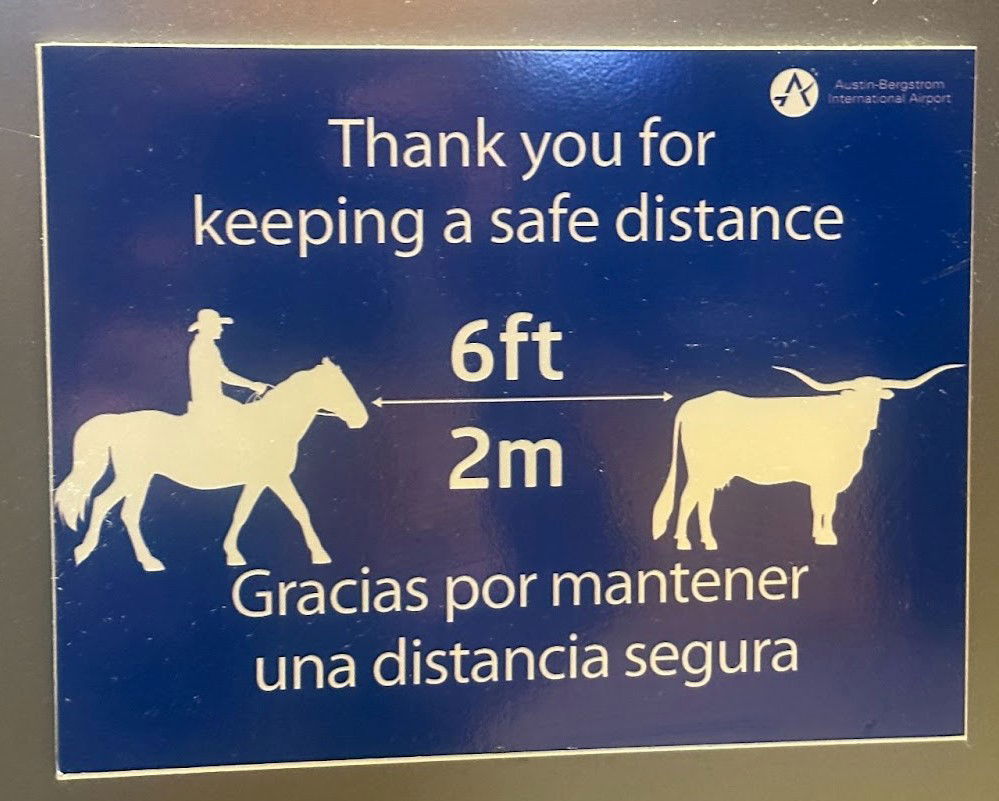 airport-keep-your-distance-texas-sign